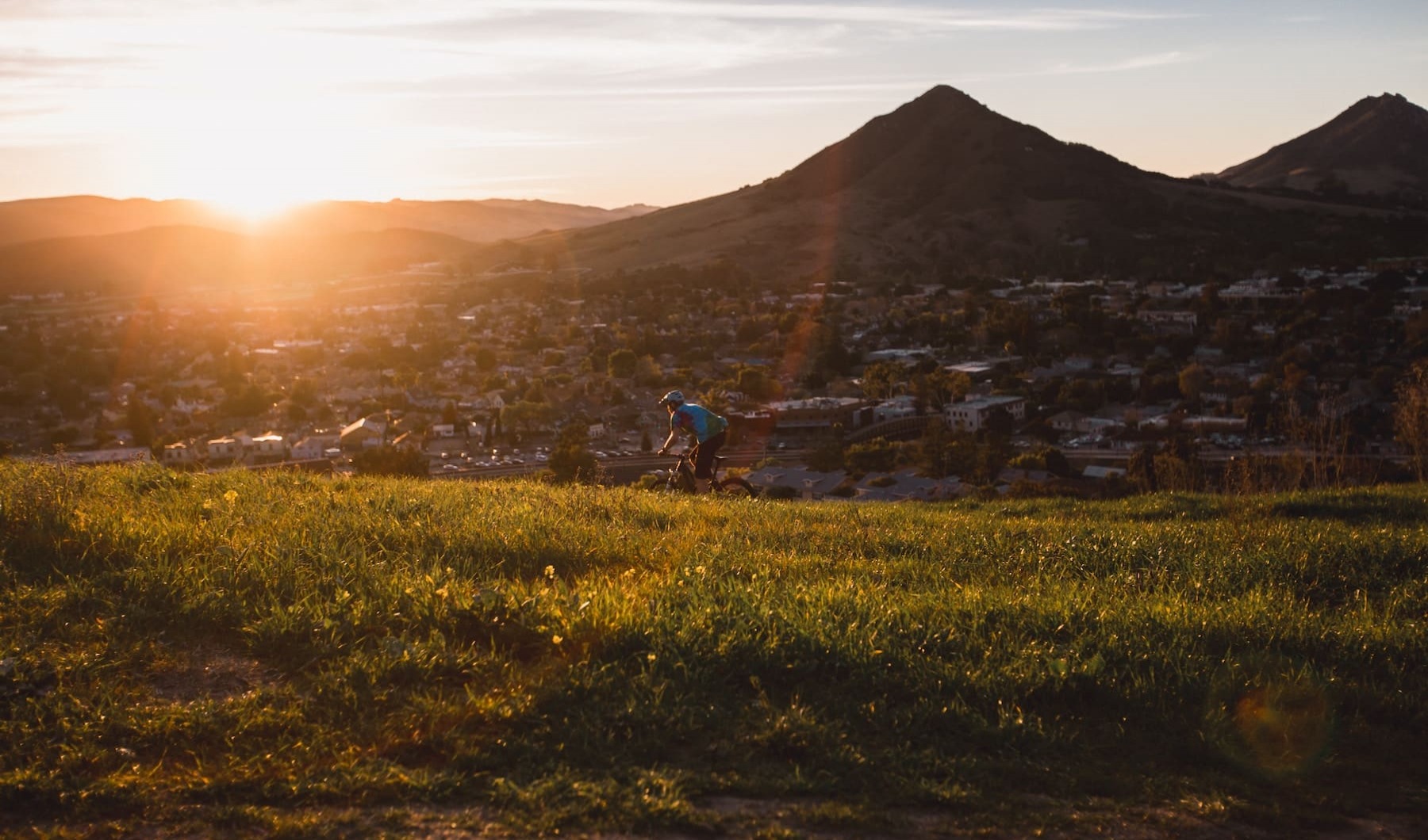 lifestyle image of a bicyclist on a trail at sunset lifestyle image of a bicyclist on a trail at sunset